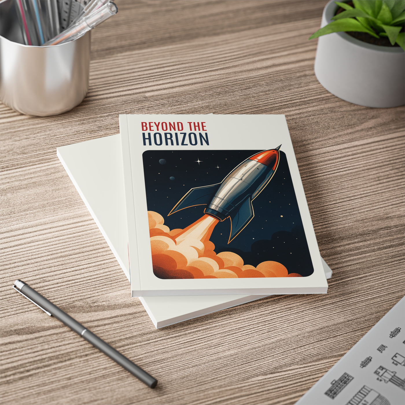 Notebook titled 'Beyond the Horizon' with a rocket illustration on a wooden surface.