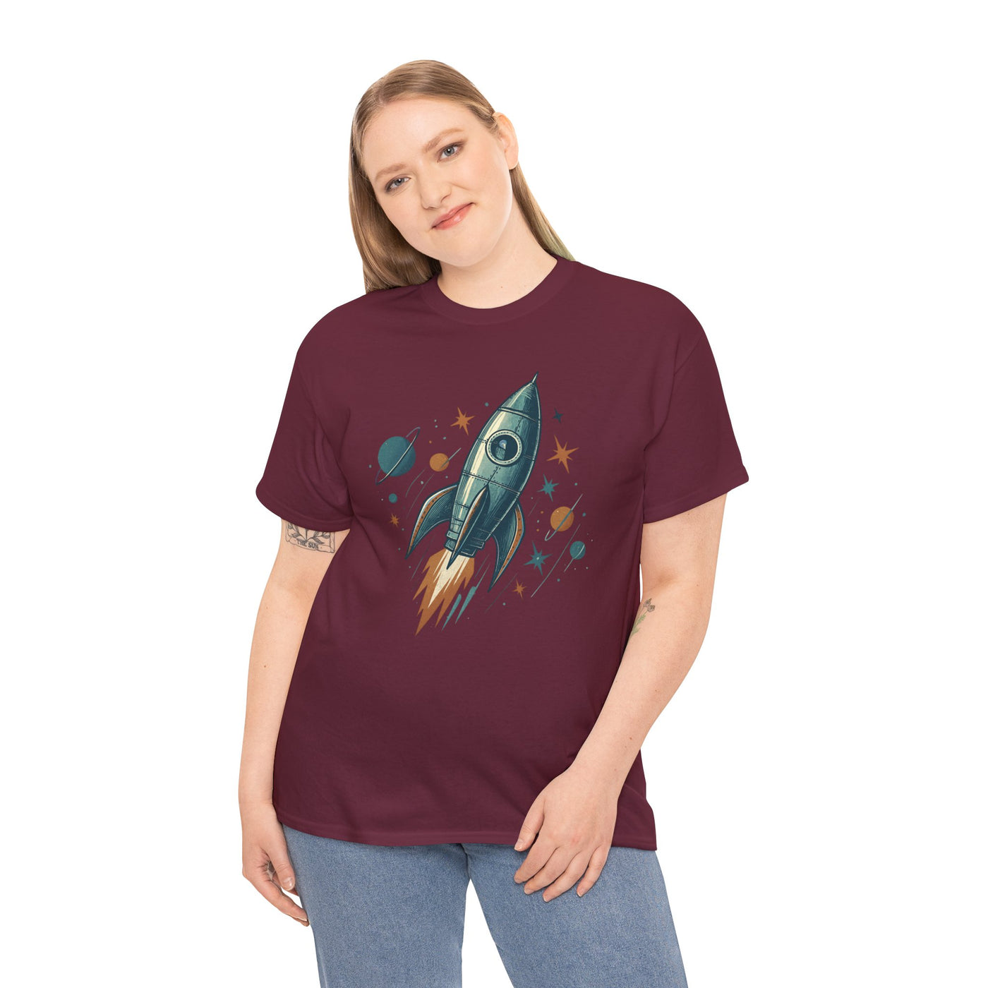 Person wearing a maroon t-shirt with a rocket ship design on a white background